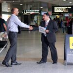 Chauffeur meeting American traveler at Heathrow Airport with a name sign